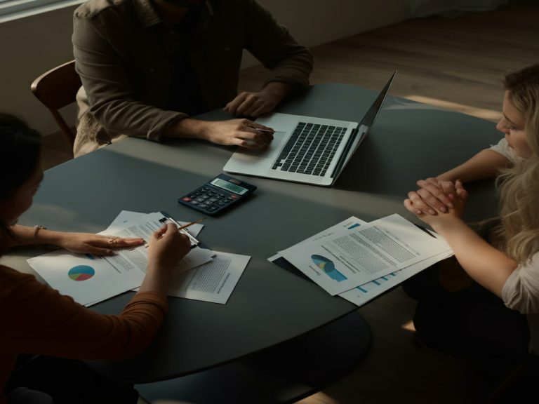 Three people discussing variable-rate mortgages in an office.